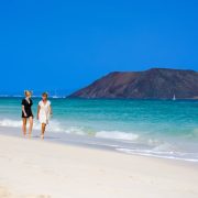 Women walking down beautiful beach in Corralejo, Spain